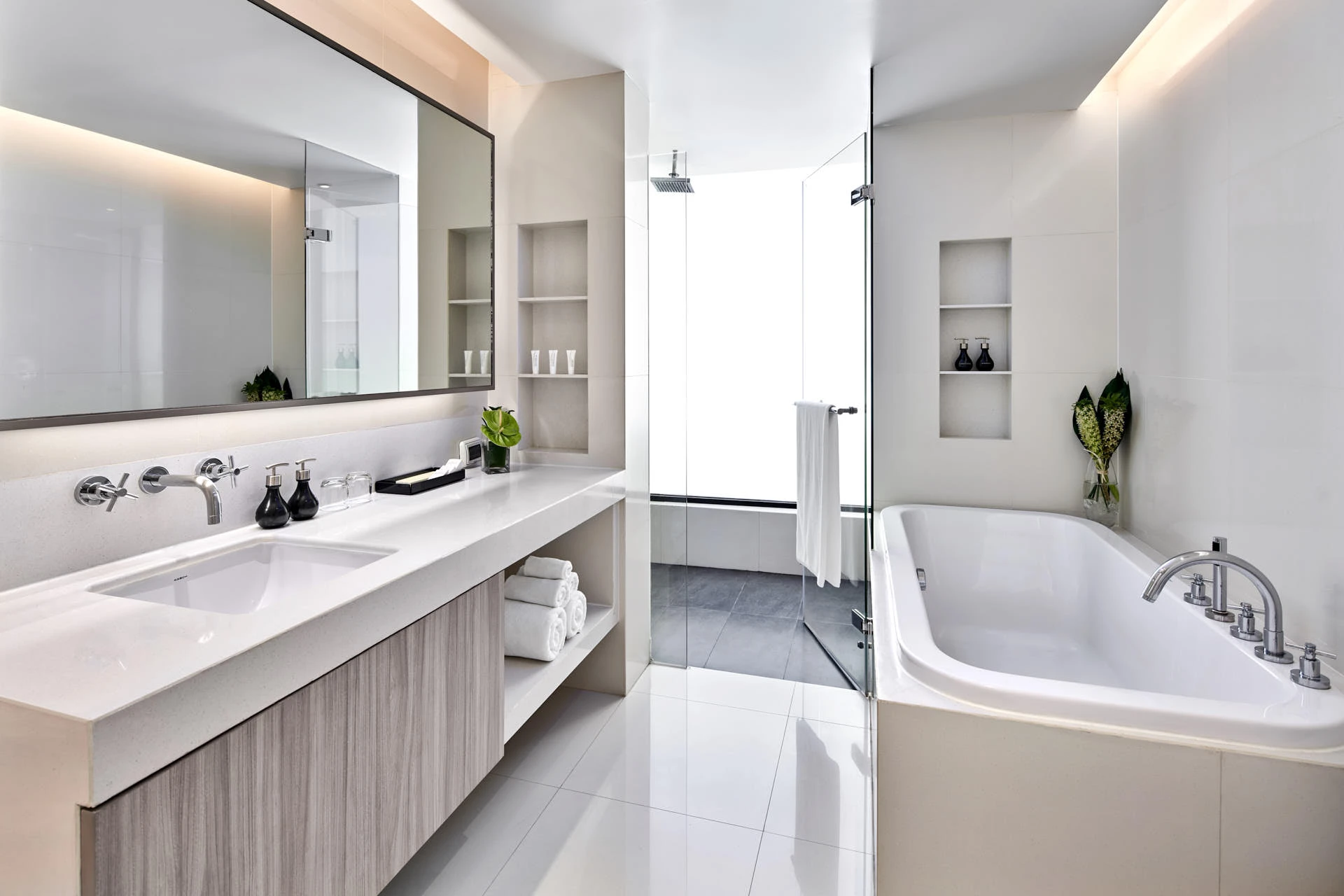 Spa bathroom with freestanding tub, rain shower and backlit mirror