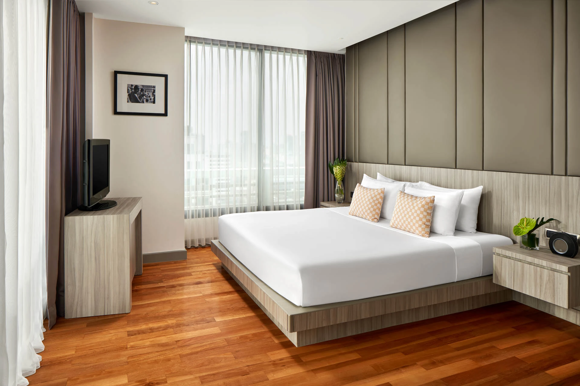 Premiere bedroom with checkered cushions and olive headboard