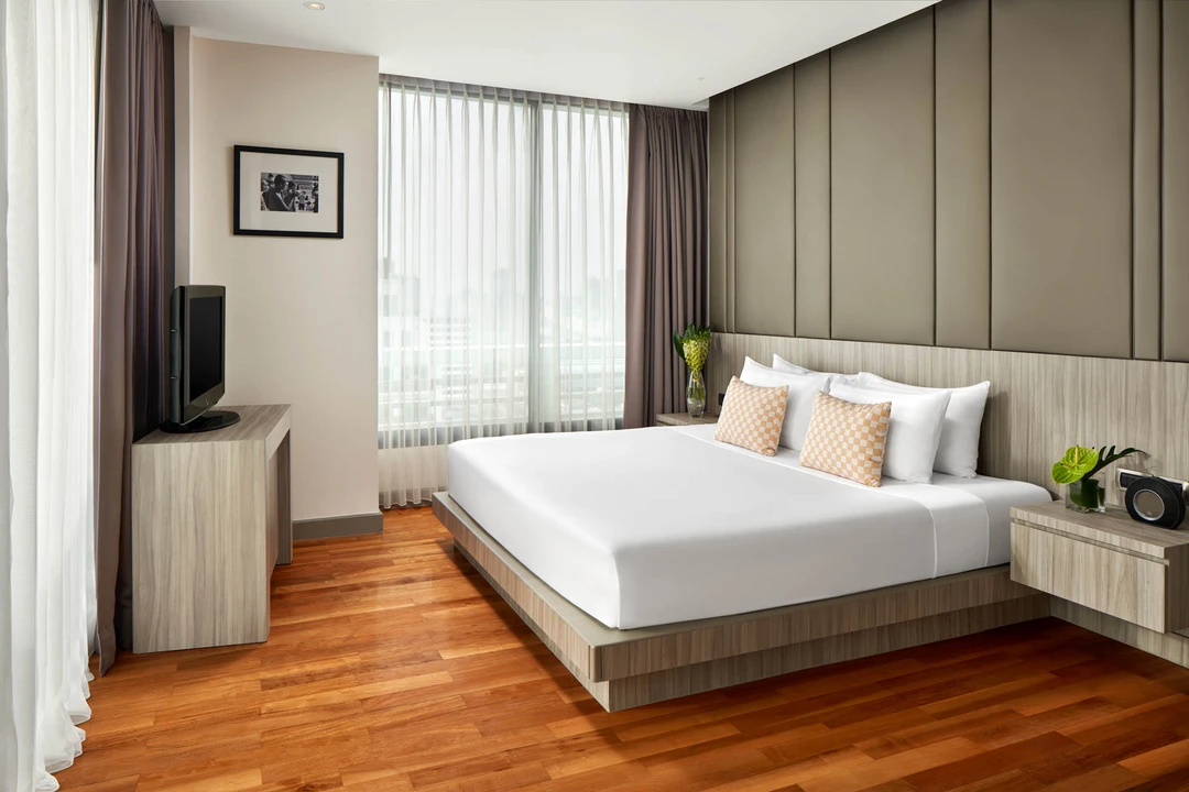 Premiere bedroom with checkered cushions and olive headboard