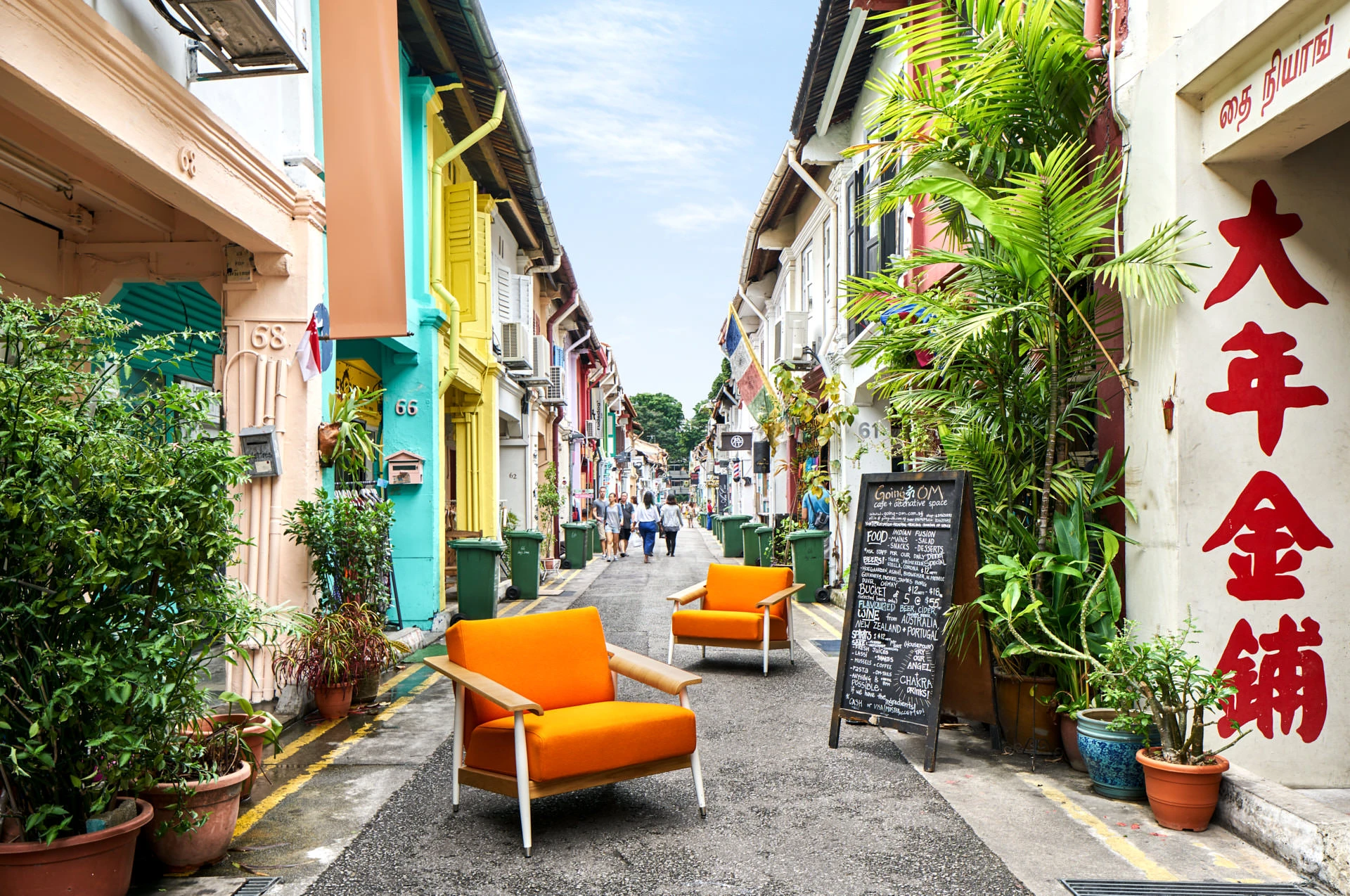 Orange mid-century armchairs on colourful Haji Lane shophouse backdrop