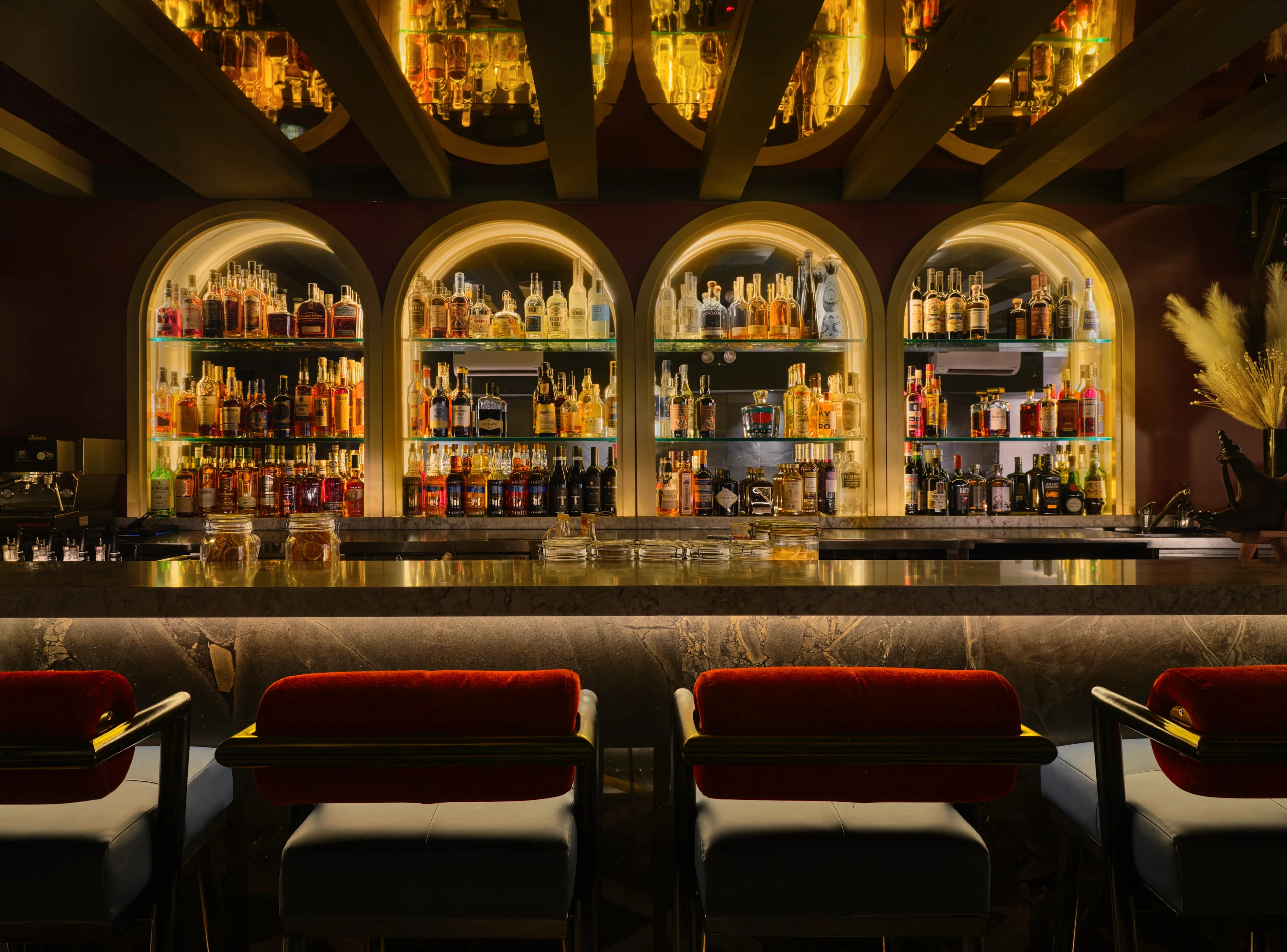 Gotti Singapore bar with symmetrical arch designs, warm lighting and black-and-gold counter