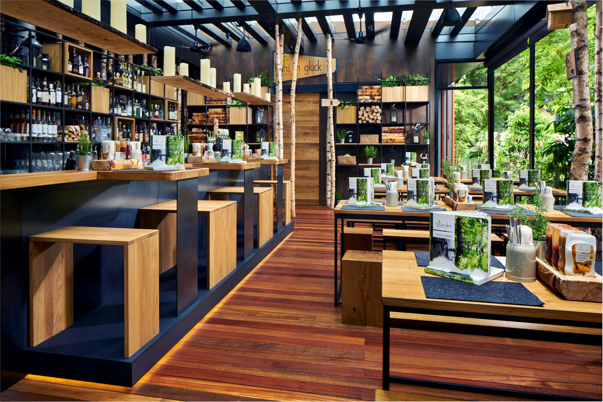 Wide-angle commercial interior photography of Hans Im Gluck restaurant by WOLF, showcasing the modern dining area with wooden tables and warm lighting.