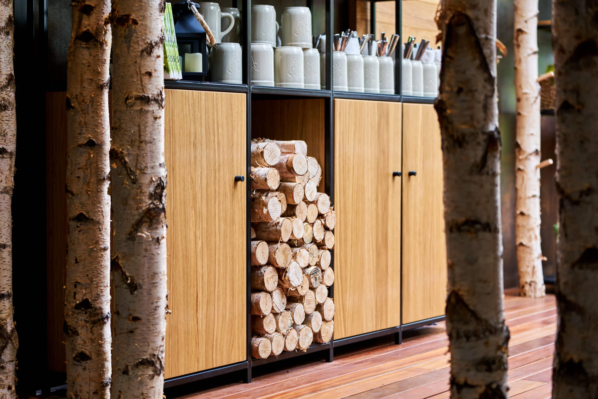 Birch tree detail next to custom wooden cabinetry at Hans Im Gluck Singapore