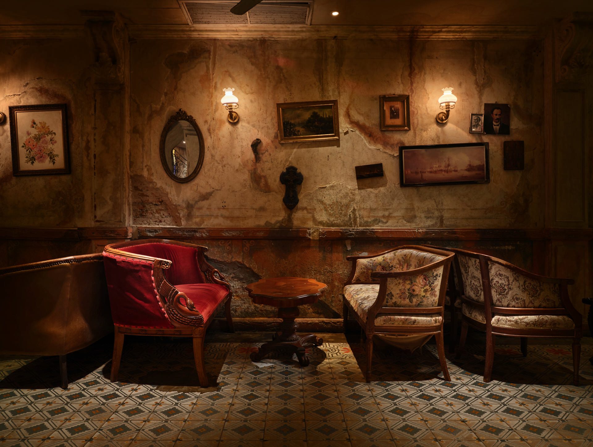Intimate corner with vintage armchairs, oval mirror and distressed walls — Havana Social Bangkok interior photography