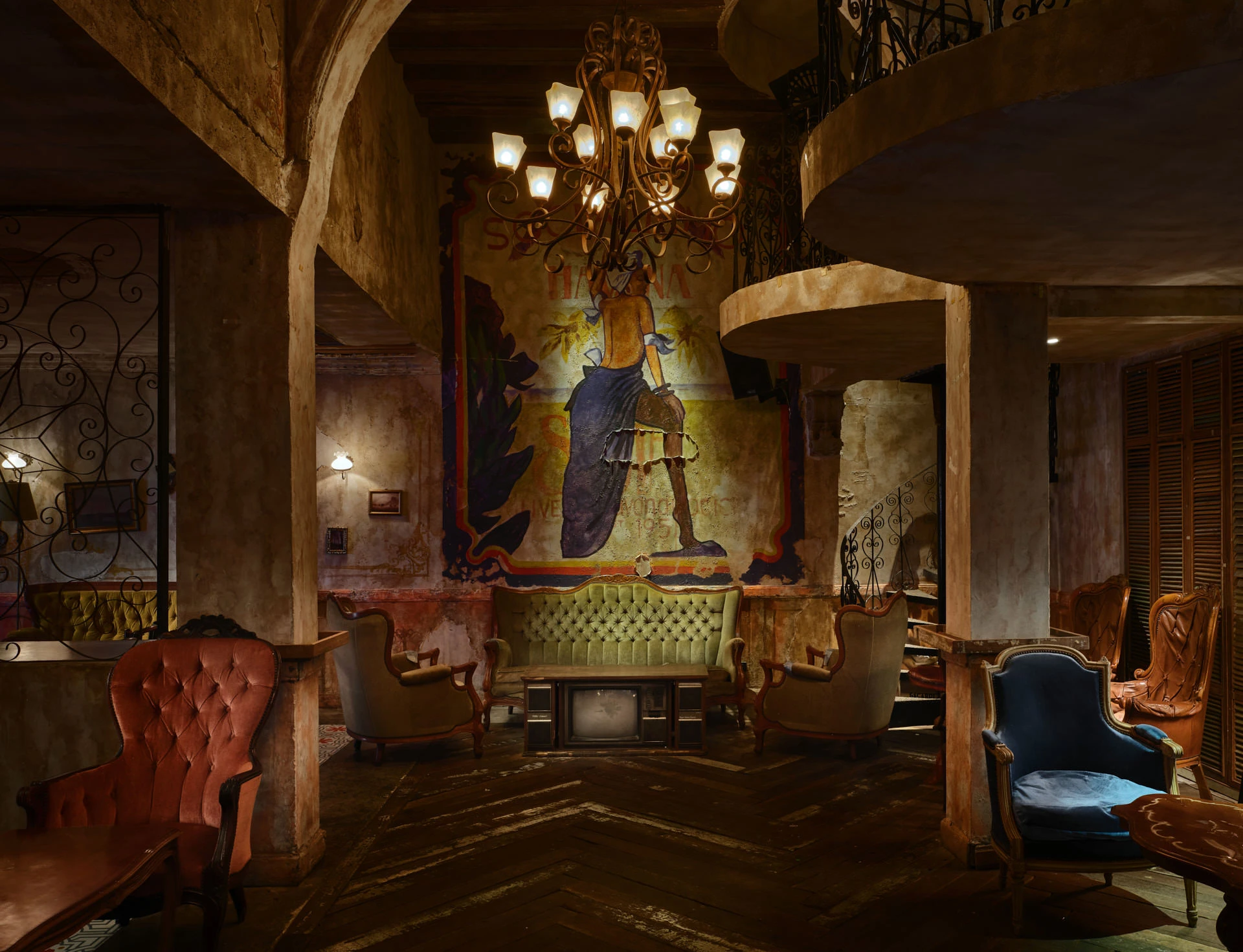Cuban mural with distressed walls, tufted settee and iron chandelier — Havana Social Bangkok interior photography