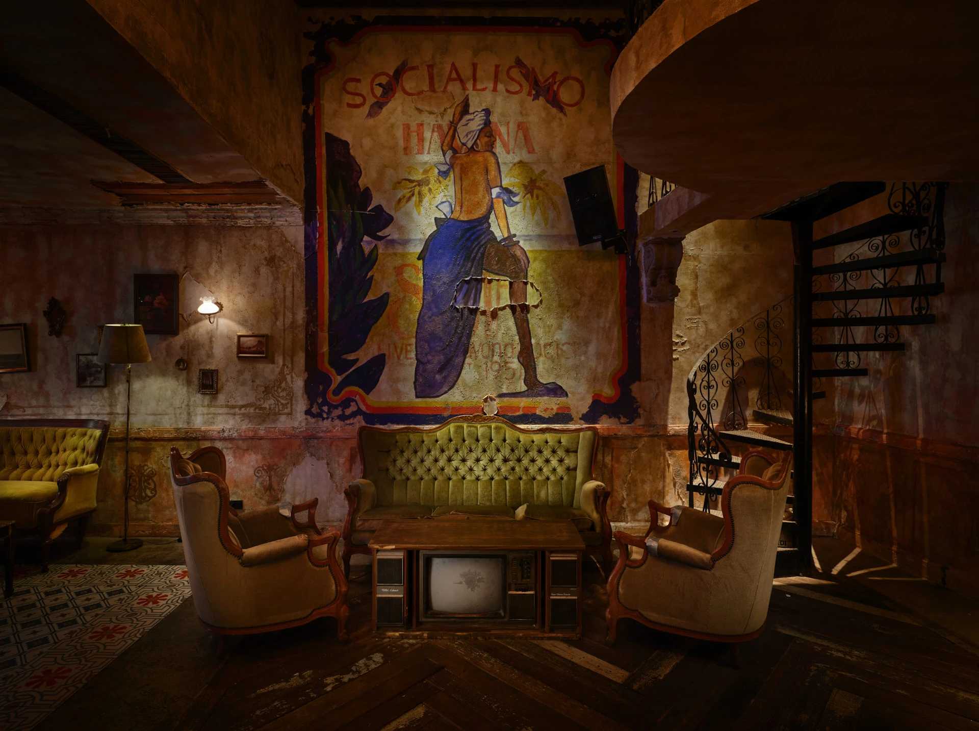 Speakeasy lounge with Socialismo mural, vintage TVs and spiral staircase — Havana Social Bangkok restaurant photography