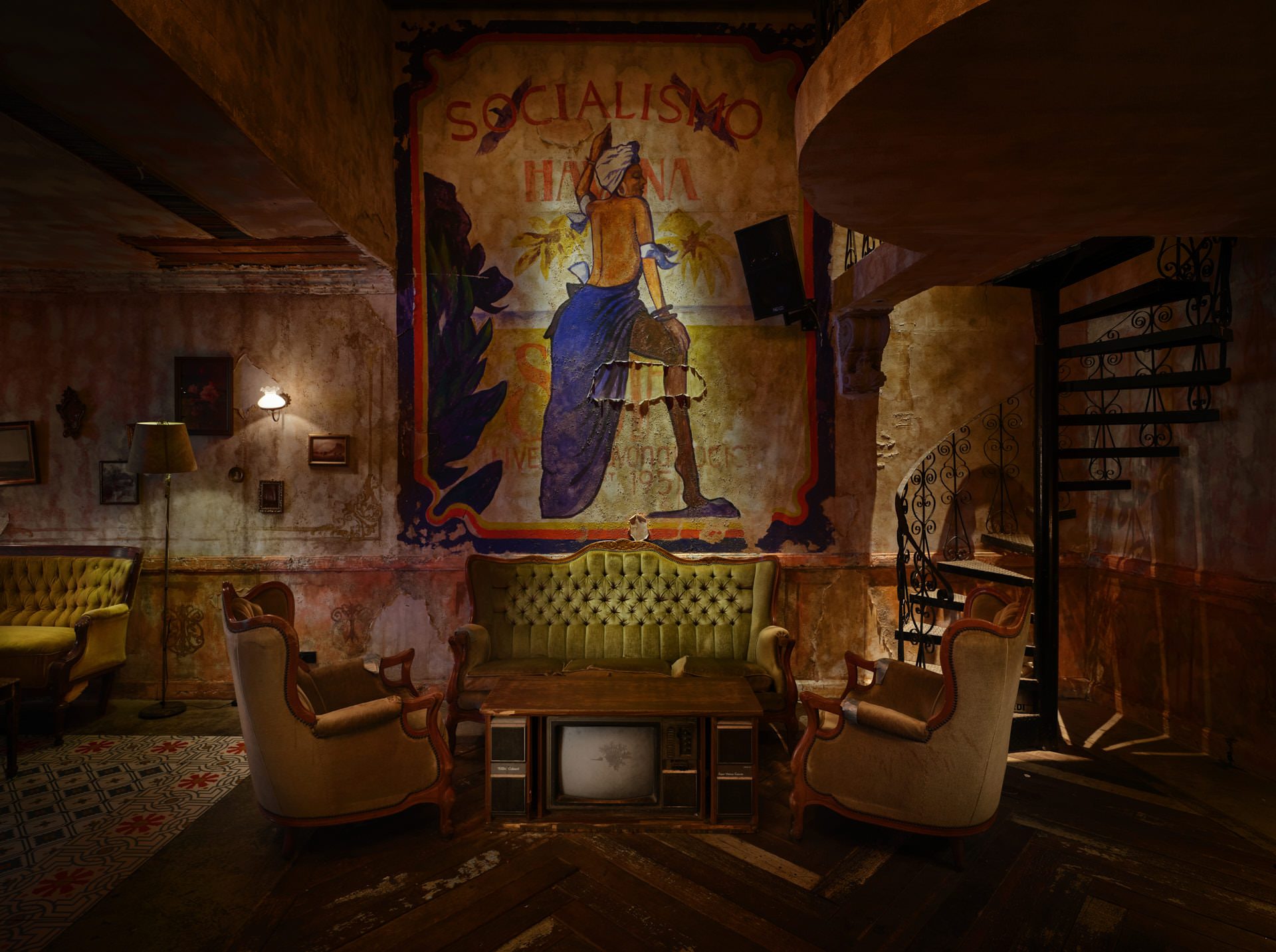 Speakeasy lounge with Socialismo mural, vintage TVs and spiral staircase — Havana Social Bangkok restaurant photography
