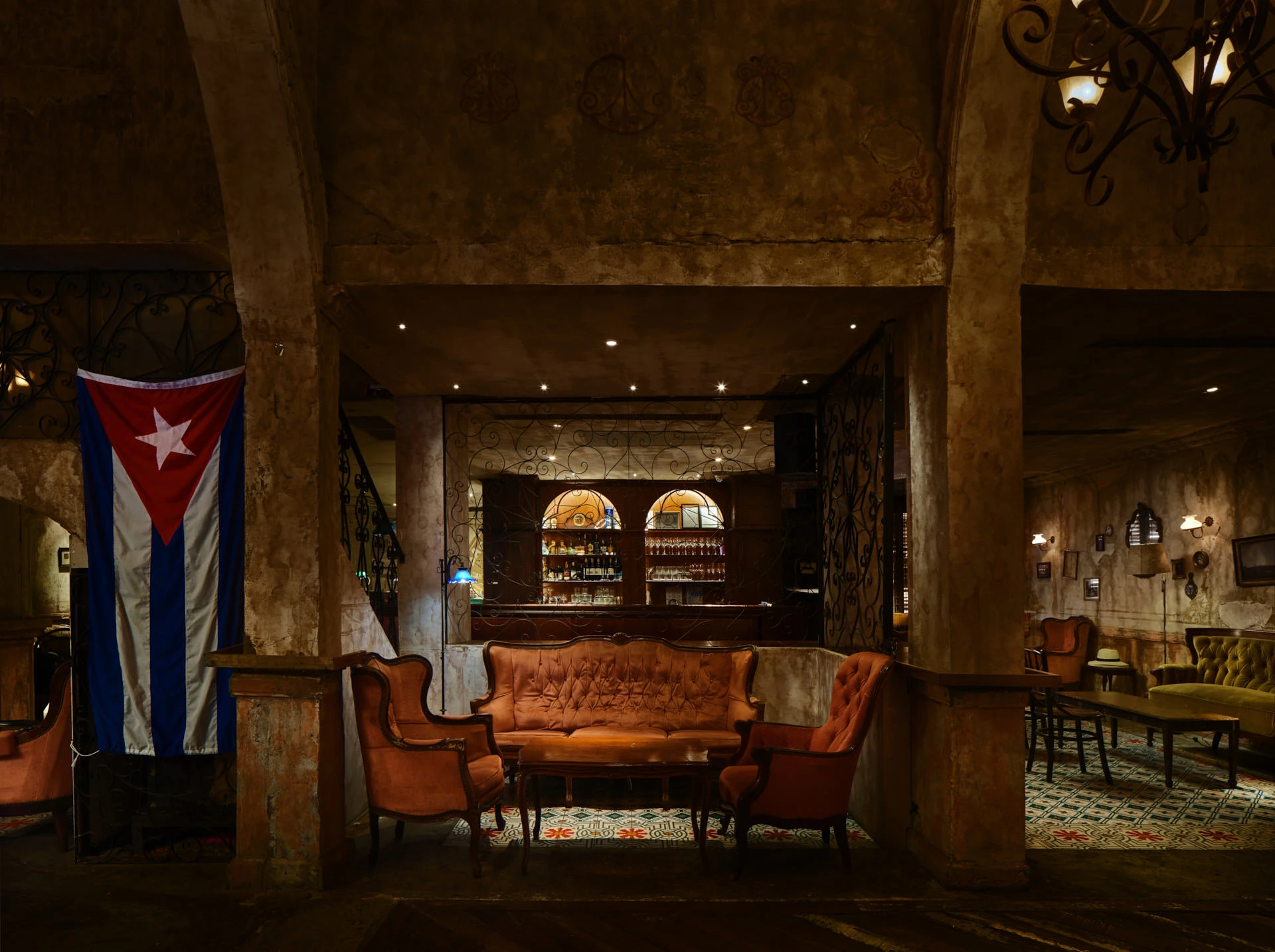 Cognac leather seating with Cuban flag and arched back-bar shelving — Havana Social Bangkok restaurant photography