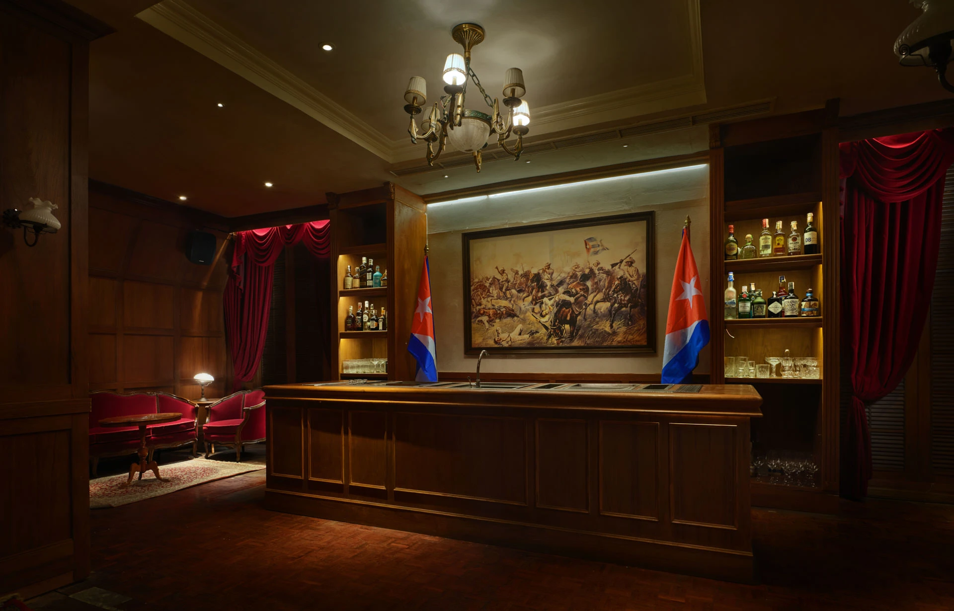El Presidente private bar with Cuban flags, battle painting and brass chandelier — Havana Social Bangkok restaurant photography