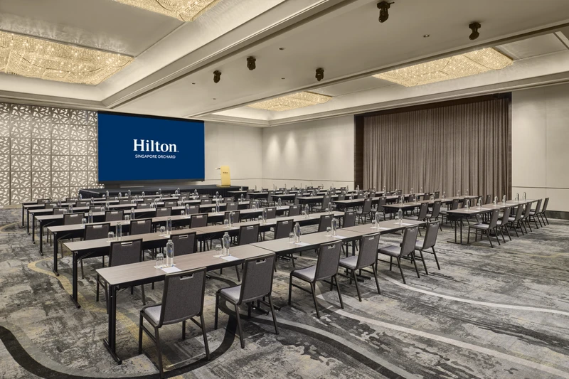 Hilton Singapore Orchard Grand Ballroom 3 in classroom setup with modern hotel meeting room seating and integrated presentation screens