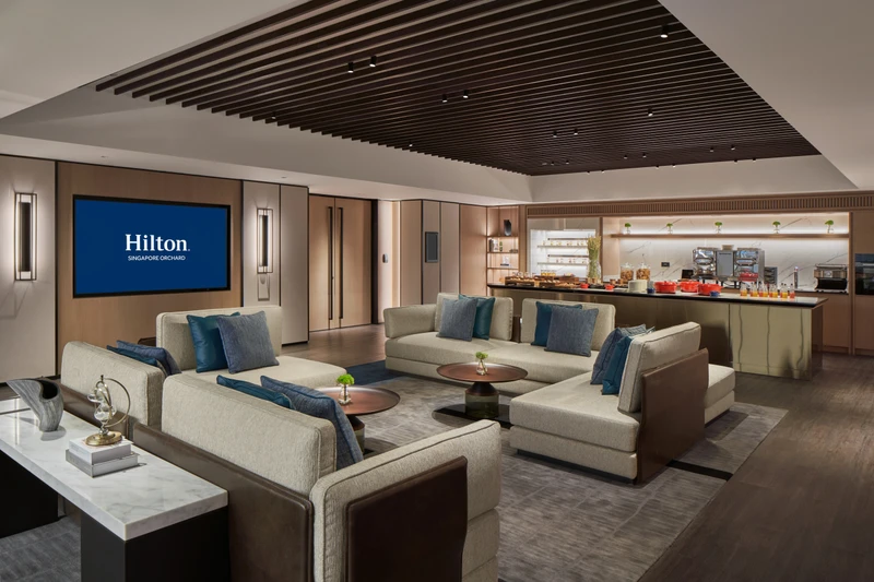 Level 5 meeting area lounge at Hilton Singapore Orchard with sofas, buffet counter and relaxed hotel function room seating