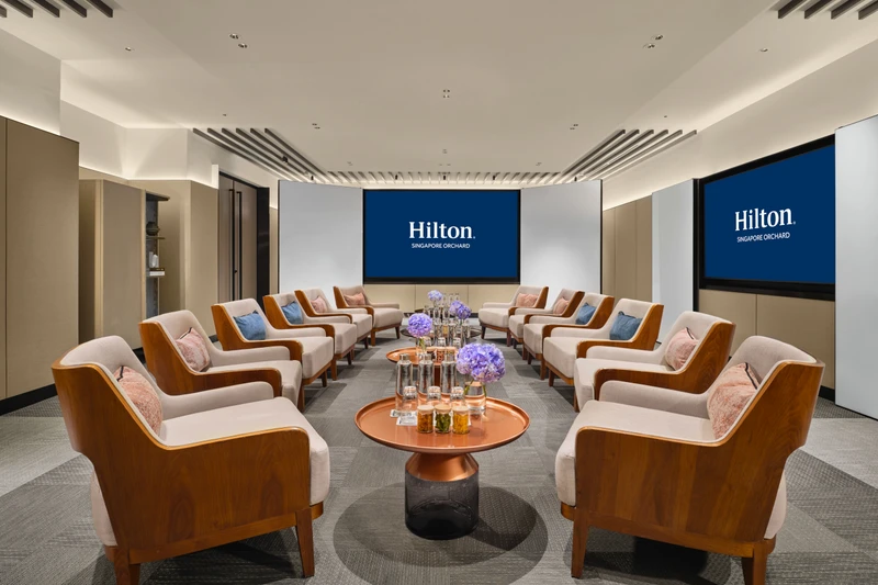 Hilton Singapore Orchard Level 5 Rhu in social event setup with modern hotel meeting room seating and integrated presentation screens