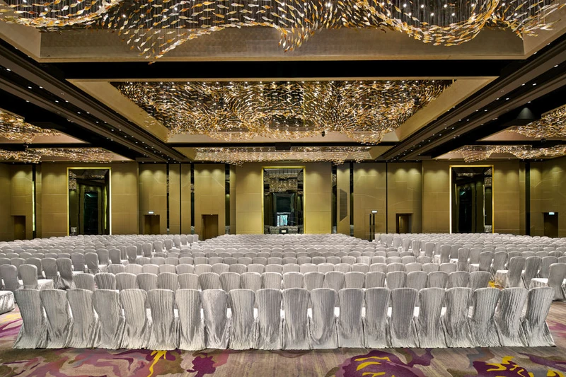 Theatre-style ballroom with swirling gold ceiling and silver chairs — Crowne Plaza Hong Kong event photography