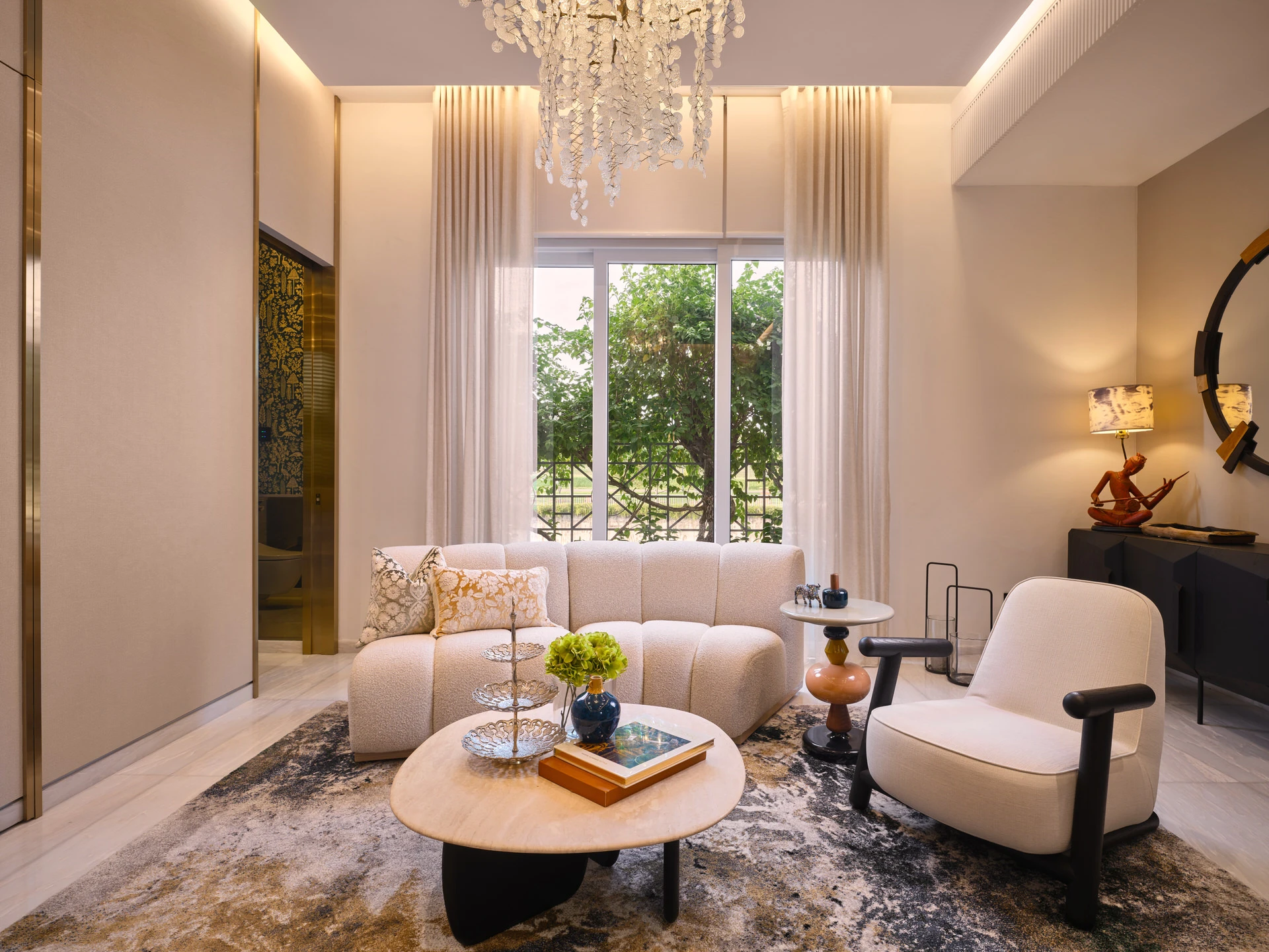 Double-height living room with pearl chandelier and bouclé sofa