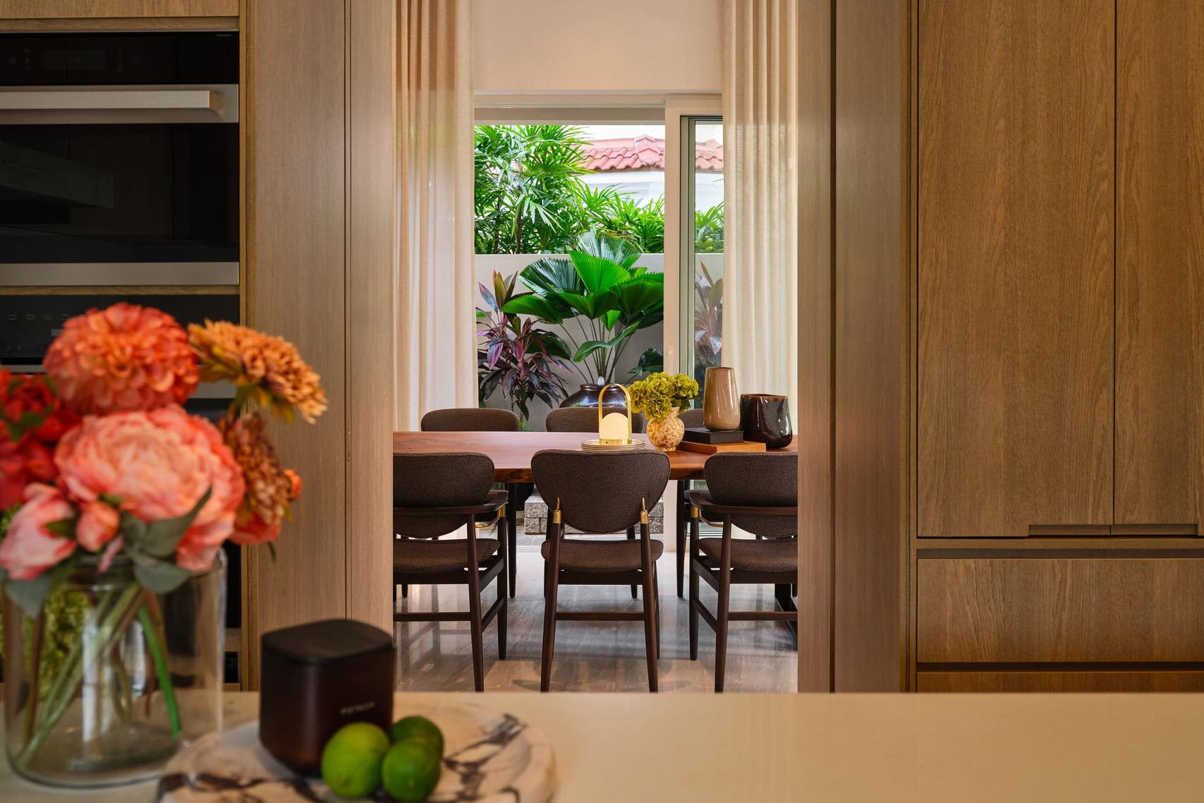 Kitchen-dining with oak cabinetry, coral peonies and garden courtyard