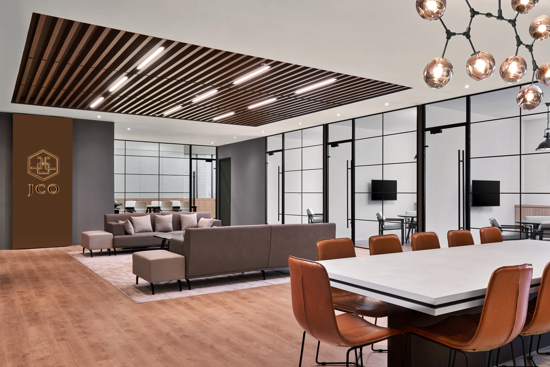 Open-plan hub with gold logo, frosted glass partitions and lounge seating