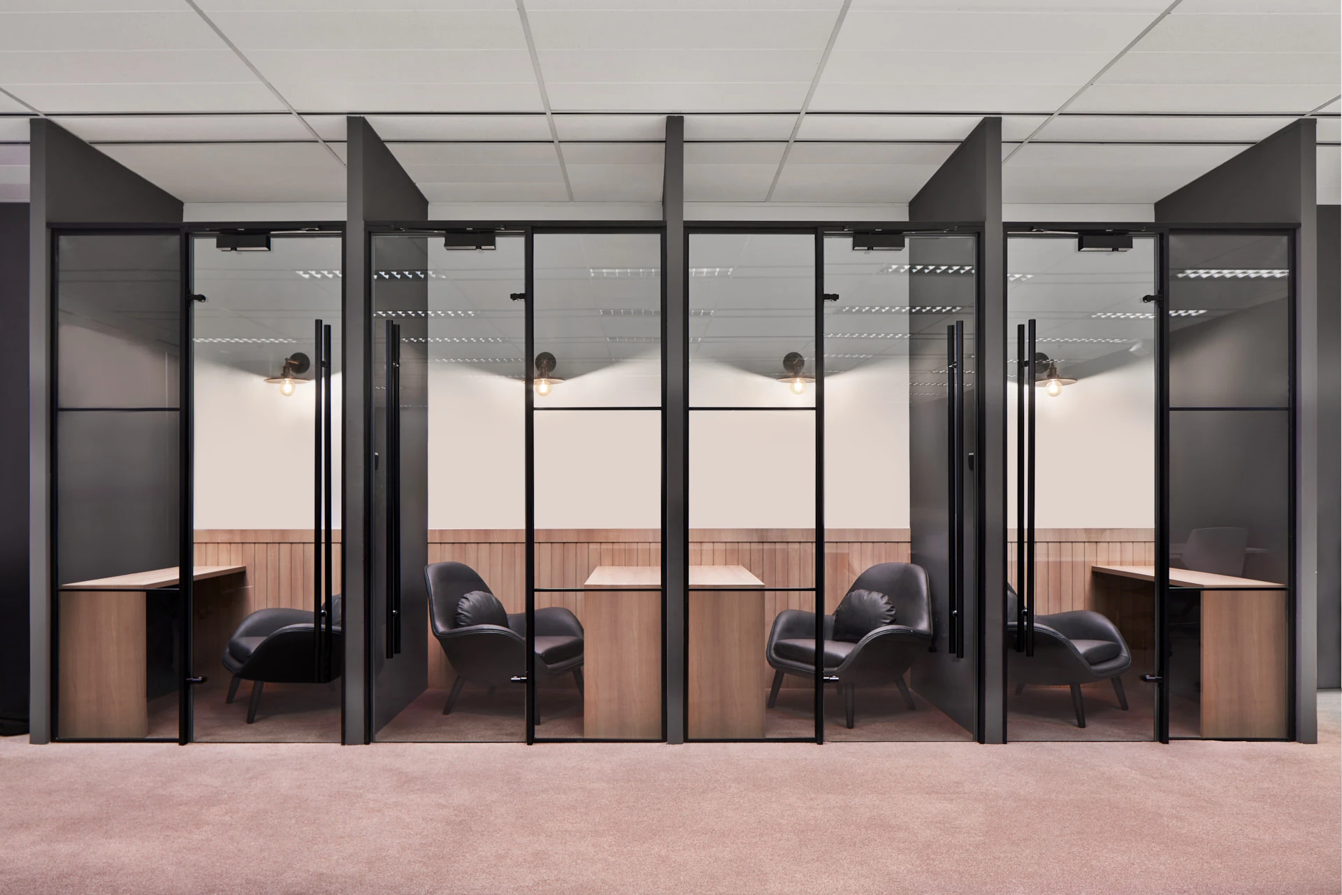 Private focus pods with glass partitions and timber desks