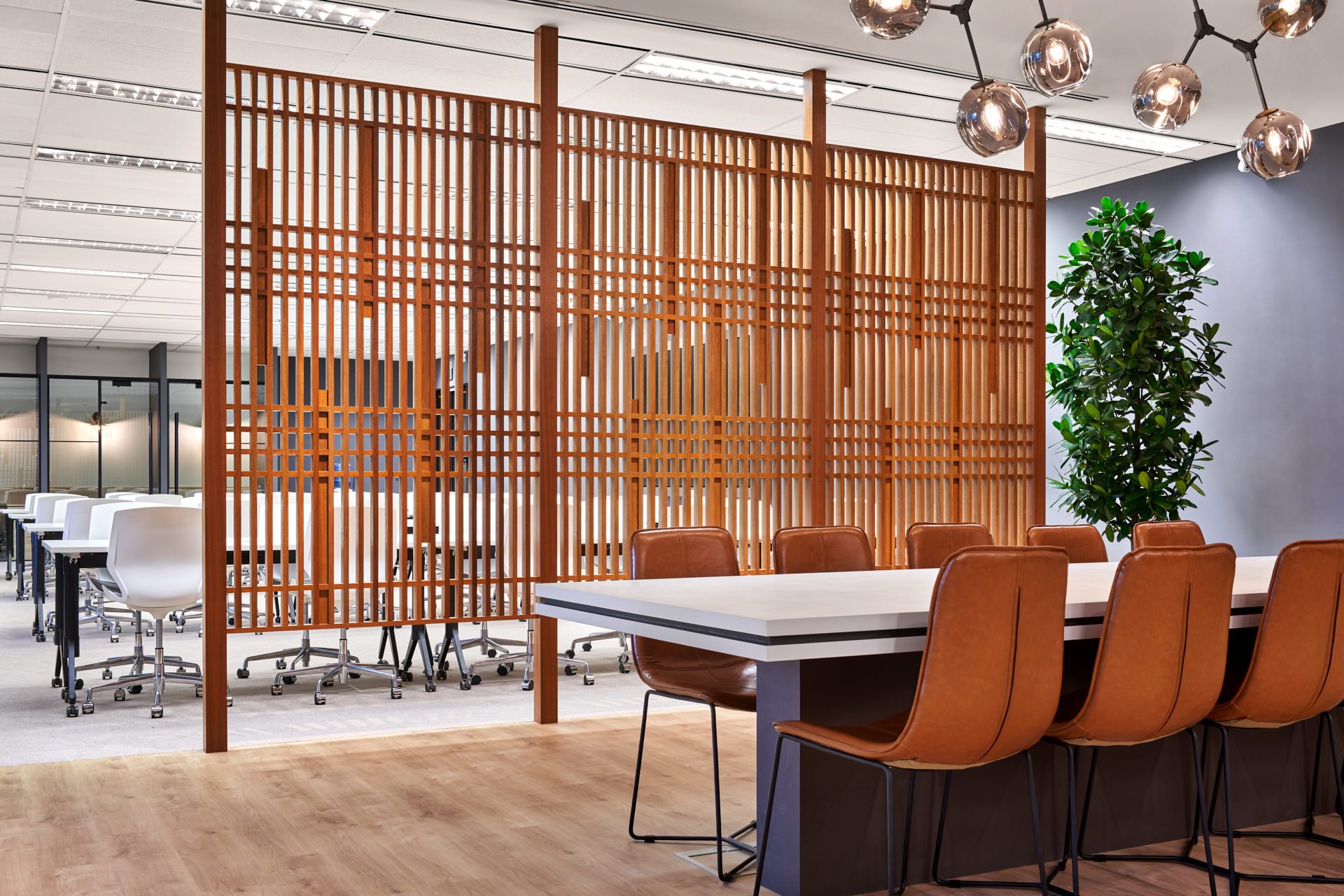 Open-plan workspace with timber slatted screen divider and leather chairs