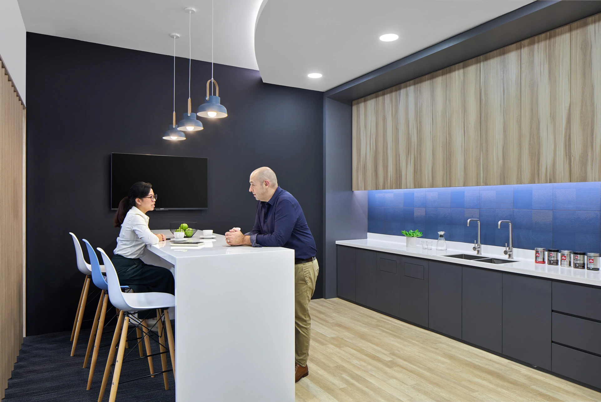 Office pantry with navy feature wall and blue pendant lamps