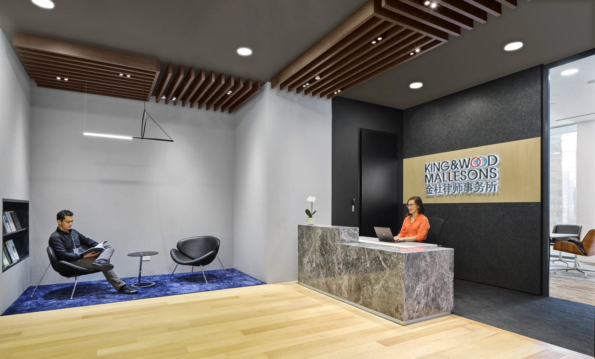 Corporate reception with marble desk, timber ceiling and mid-century lounge