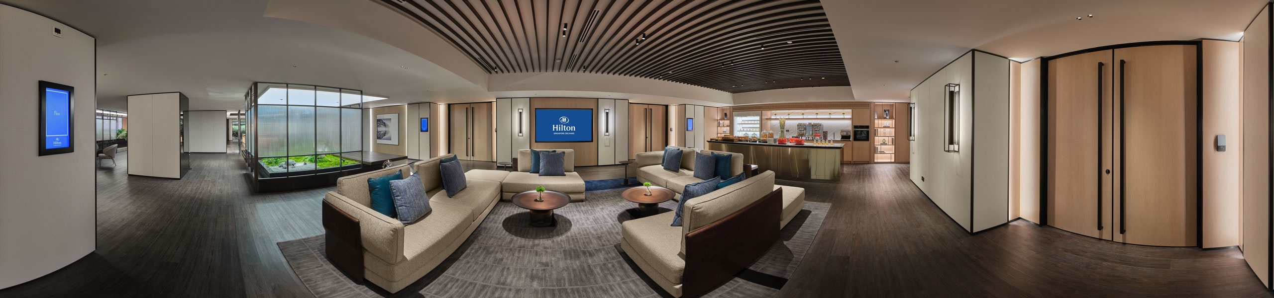 360 panorama of Hilton Singapore Orchard level 5 executive lounge with sofas, green planter and breakfast bar