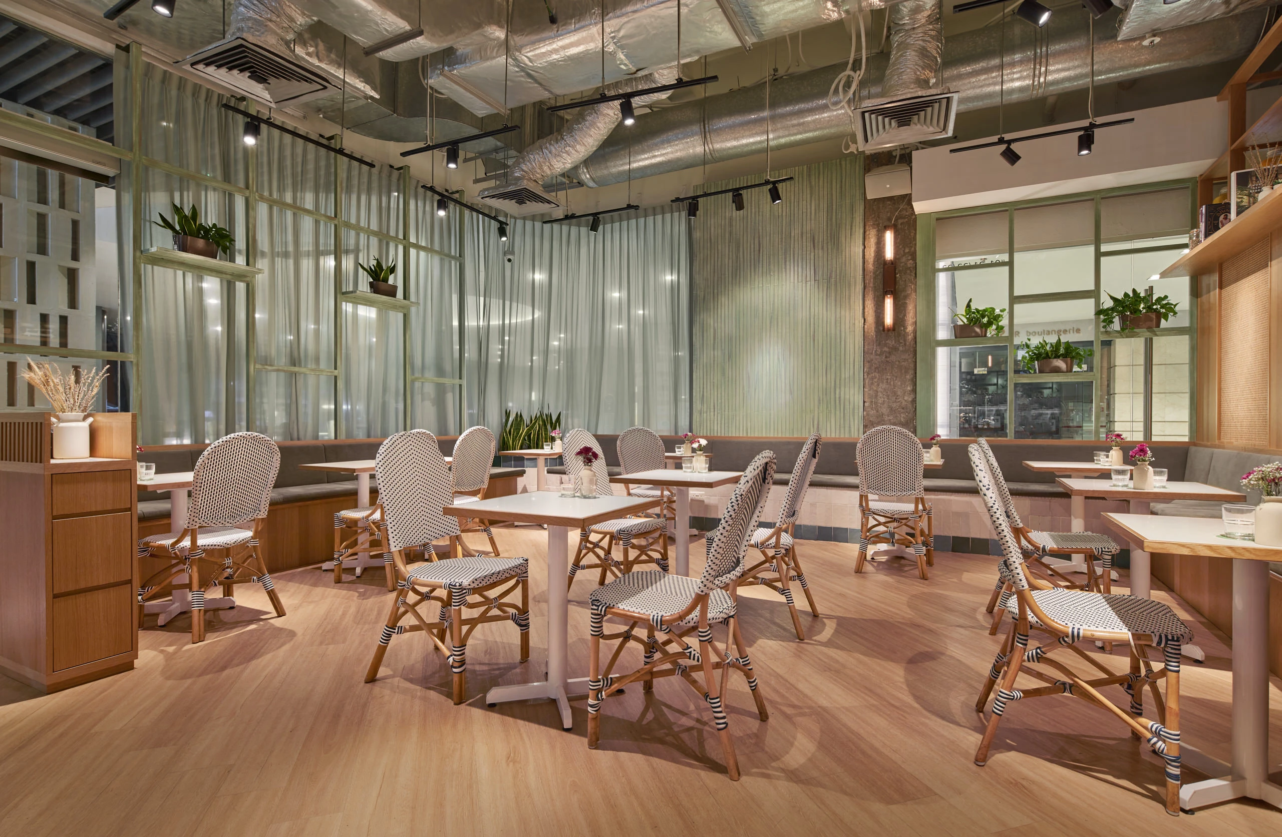 Dining area with natural light, timber tables and rattan pendant lights