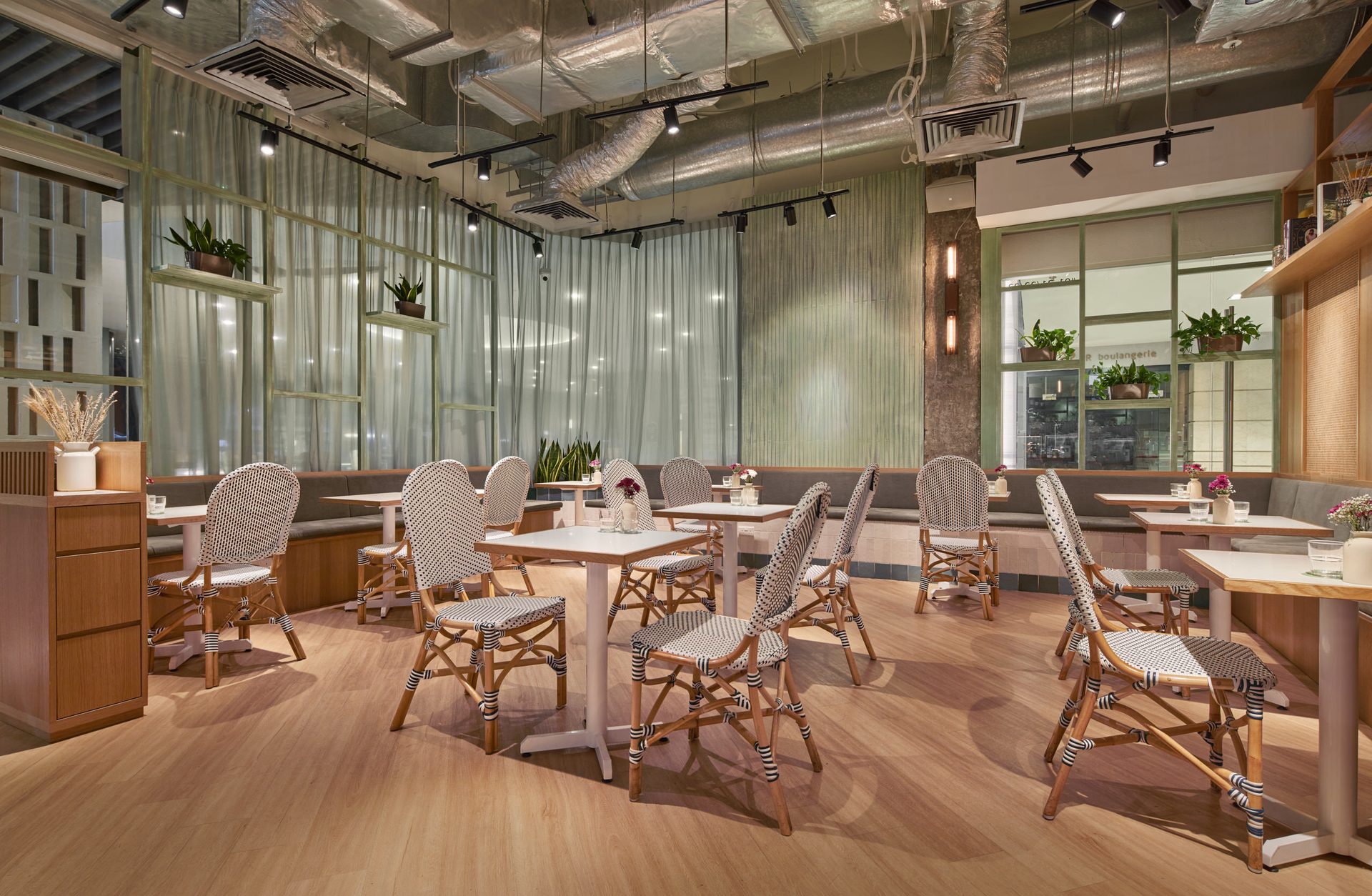 Dining area with natural light, timber tables and rattan pendant lights