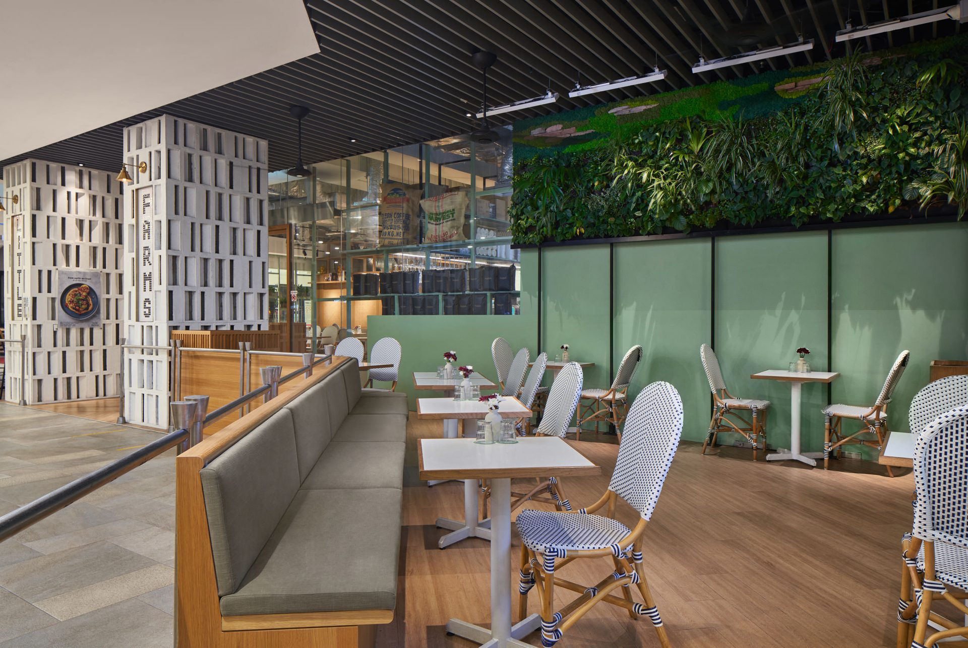 Outdoor dining area with greenery and cushioned seating