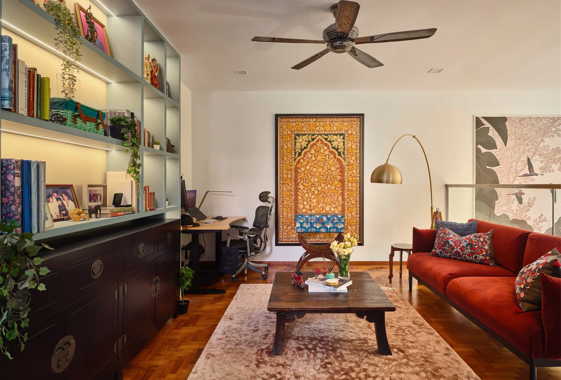 Serangoon Chuan Drive study lounge by Nidhi Jain with red leather sofa, built-in shelves, patterned rug and framed artwork