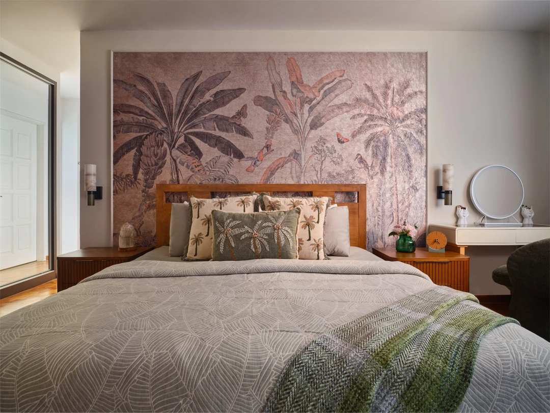Serangoon Chuan Drive bedroom detail by Nidhi Jain with palm mural, timber headboard, layered pillows and bedside styling