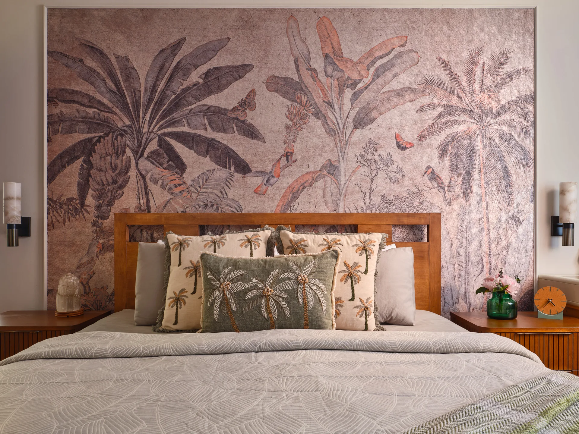 Serangoon Chuan Drive bedroom detail by Nidhi Jain with palm mural, timber headboard, layered pillows and bedside styling