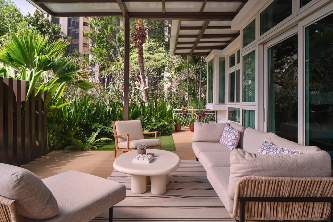 Bayshore residence by Nidhi Jain with covered garden terrace, rattan sofa and tropical planting, crop detail
