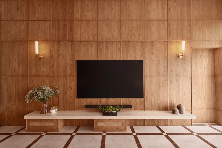 Bayshore residence TV wall by Nidhi Jain with timber paneling, wall sconces and low console joinery, crop detail