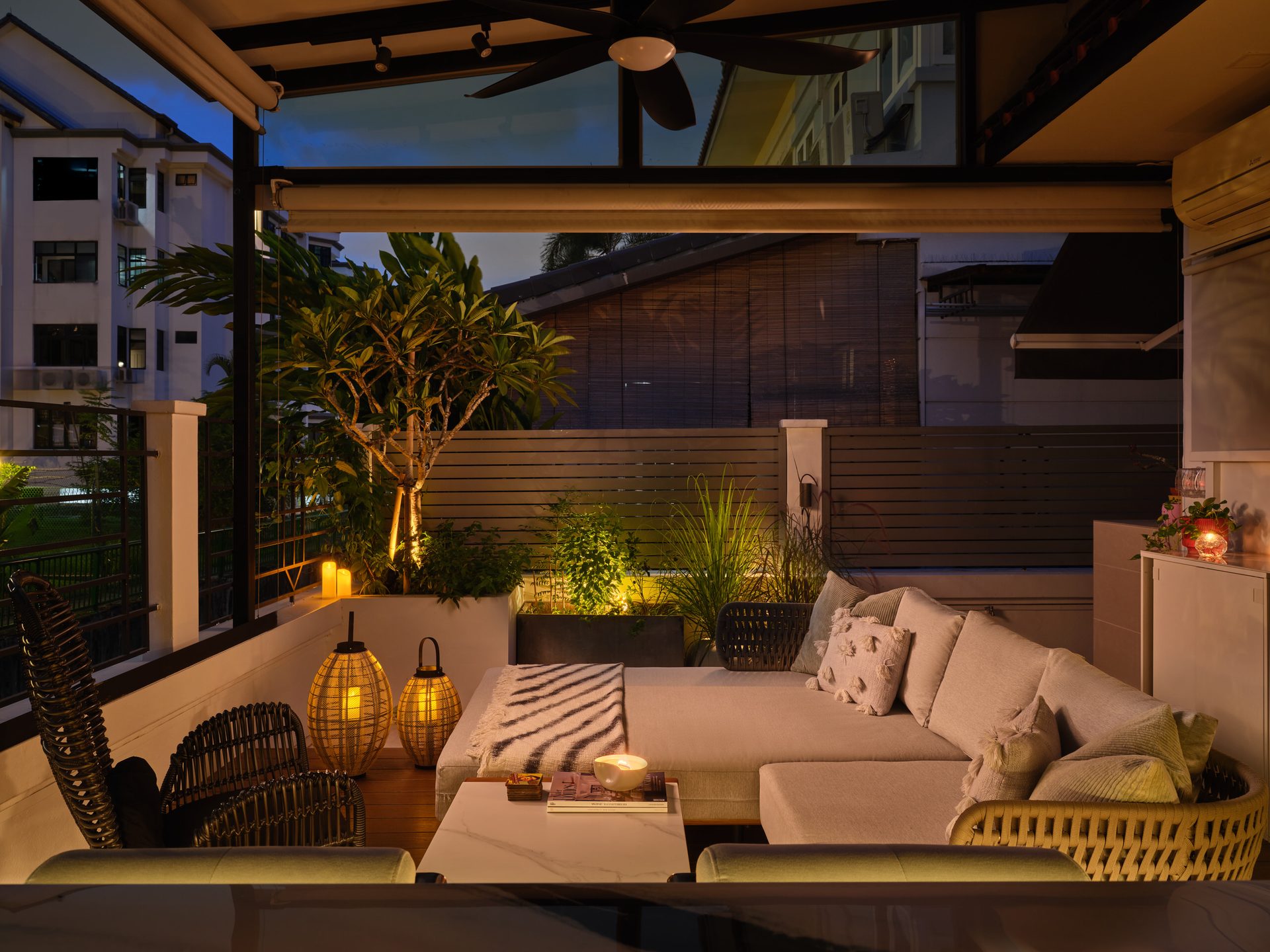 Covered rear lounge with plush cushions, string lights and tropical planting