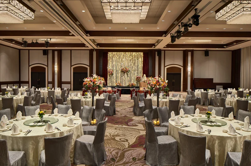 Paradox Singapore ballroom wedding banquet with ivory linens, floral aisle, and fairy-light backdrop