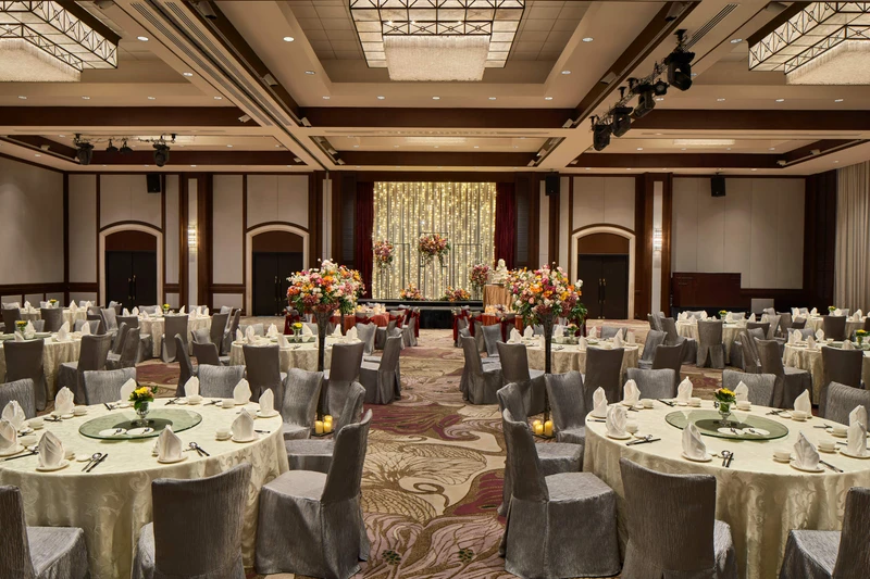 Paradox Singapore ballroom wedding banquet with ivory linens, floral aisle, and fairy-light backdrop