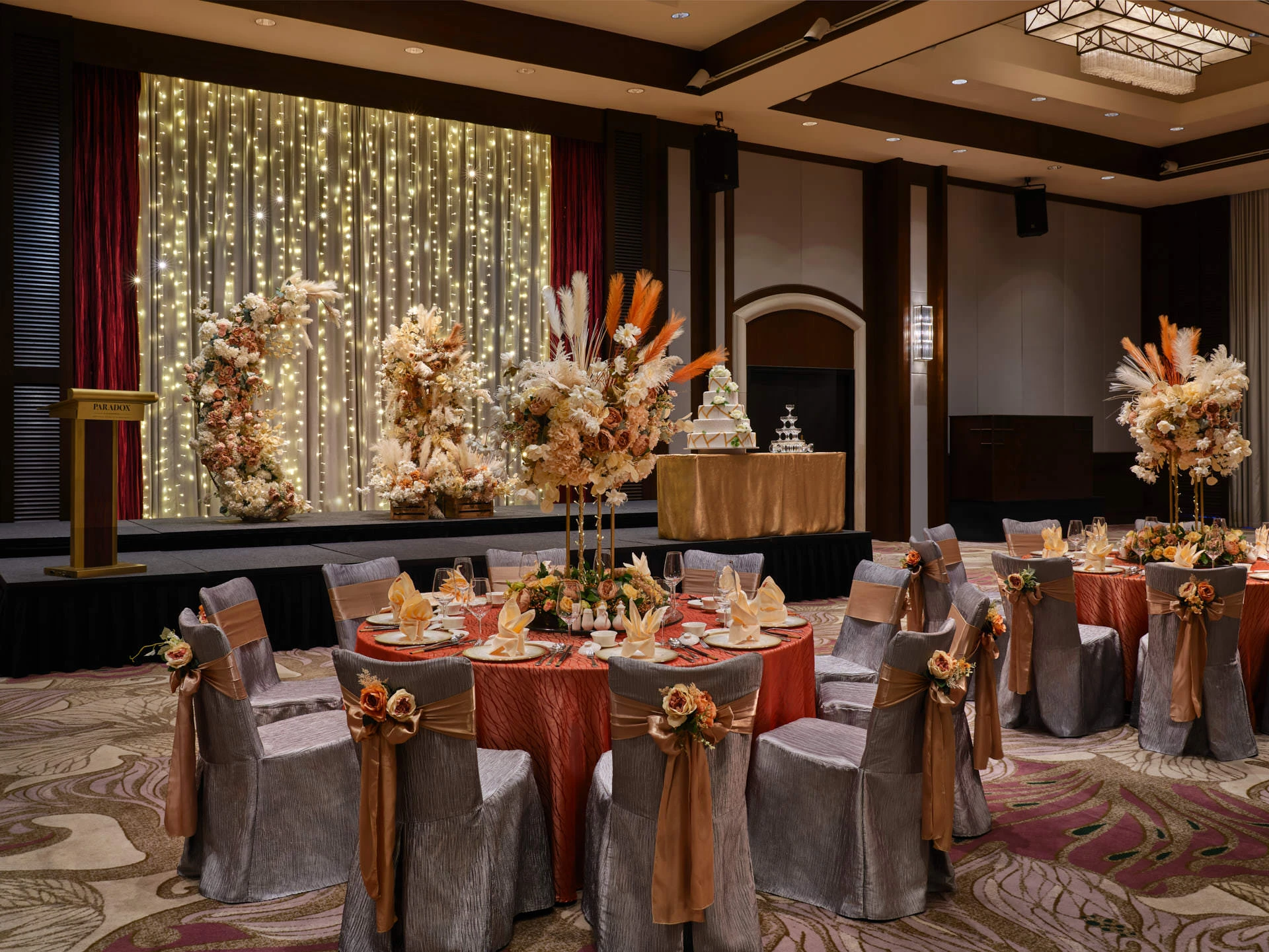 Autumnal wedding with burnt-orange linens, dried roses and gold accents - Paradox Singapore function room photography