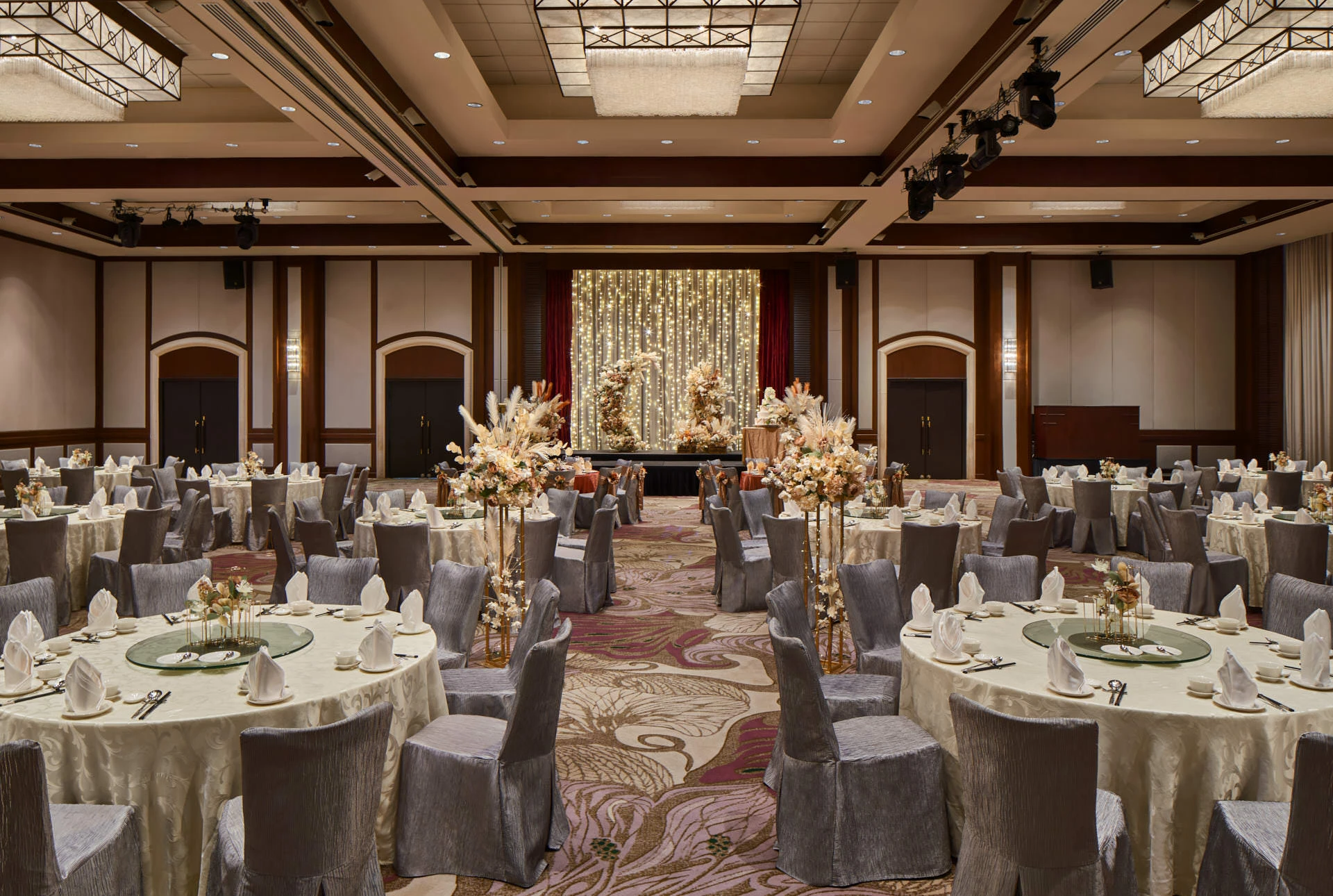 Bohemian wedding with pampas grass, cream blooms and fairy-light stage - Paradox Singapore ballroom photography