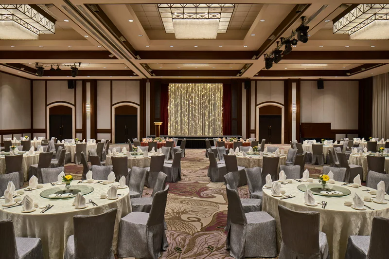 Paradox Singapore dinner and dance banquet with silver chairs, floral centrepieces, and fairy-light stage