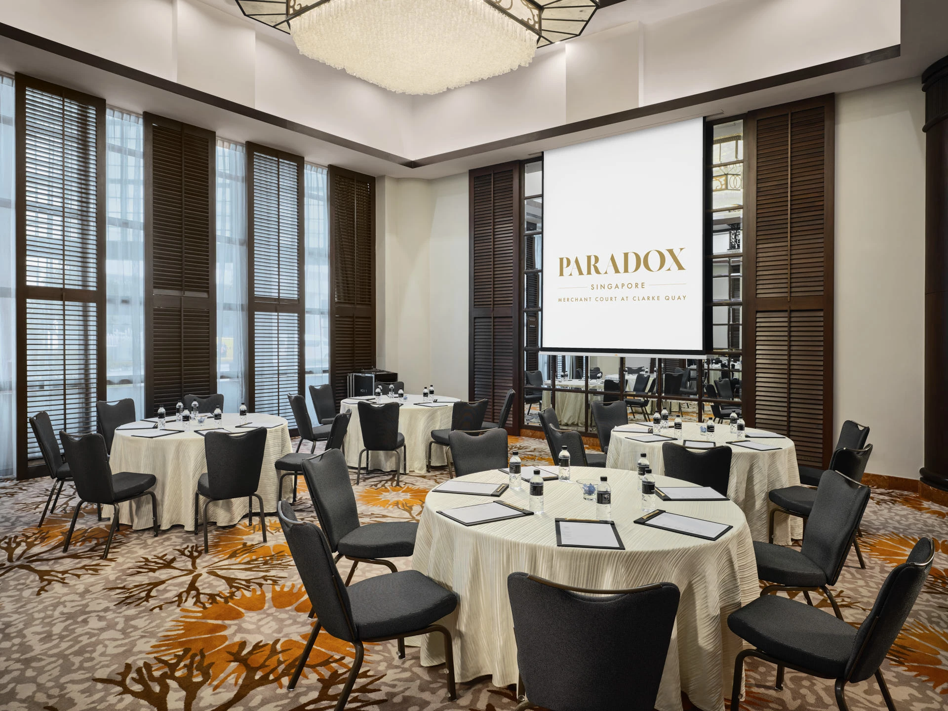 Heritage function room with louvred shutters, crystal chandelier and coral carpet - Paradox Singapore event photography