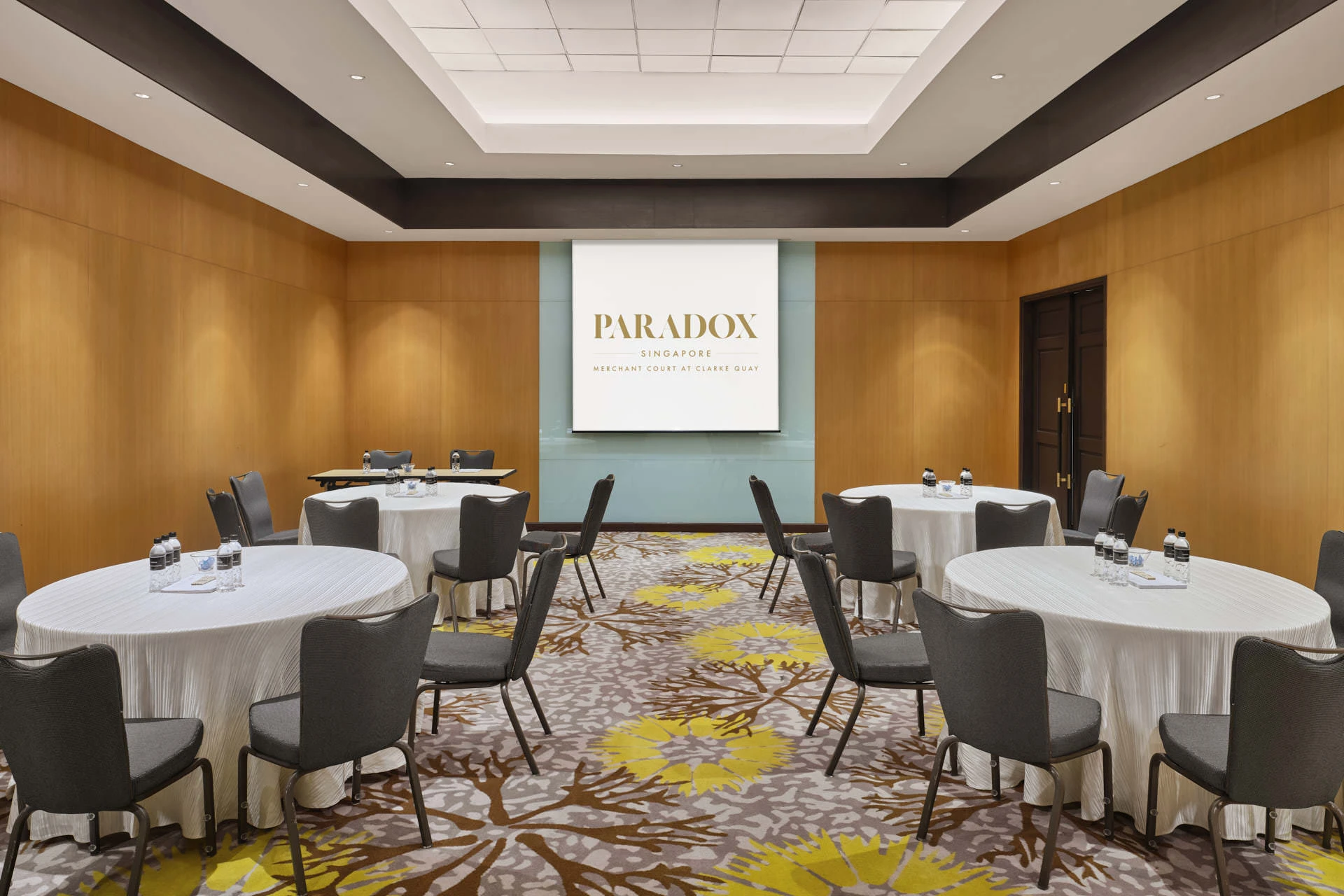 Crescent-round conference with gridded ceiling panel and blue accent wall - Paradox Singapore meeting room photography