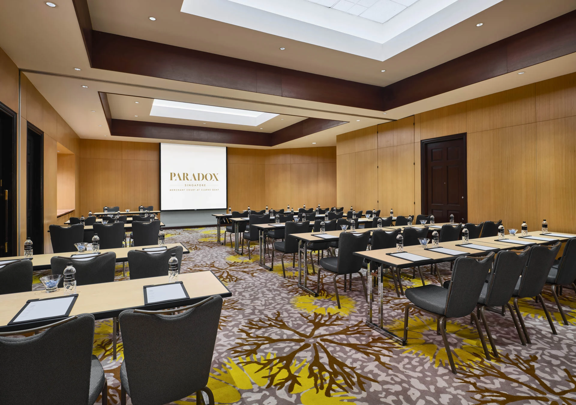 Classroom conference setup with branded screen and timber panels - Paradox Singapore meeting room photography