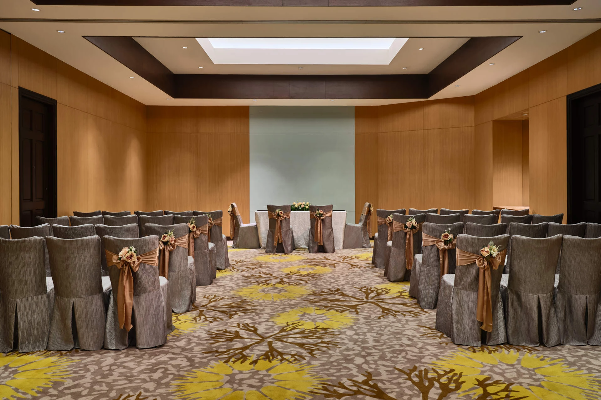Theatre-style ceremony room with velvet chairs and frosted glass wall - Paradox Singapore function room photography