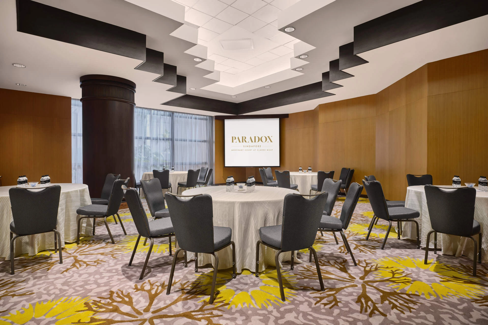 Cabaret round setup with geometric ceiling sculpture and sheer curtains - Paradox Singapore function room photography