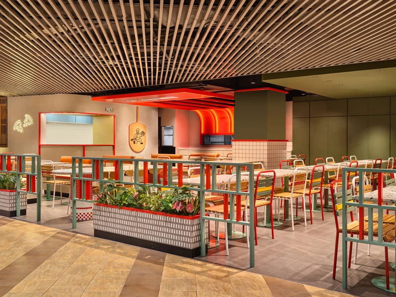 Dining area with timber ceiling, colourful chairs and greenery planters at PastaMania Causeway Point