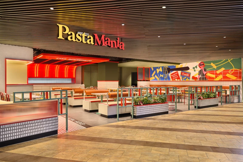 Wide view with pop-art mural, red canopy and tiered booth seating at PastaMania Causeway Point