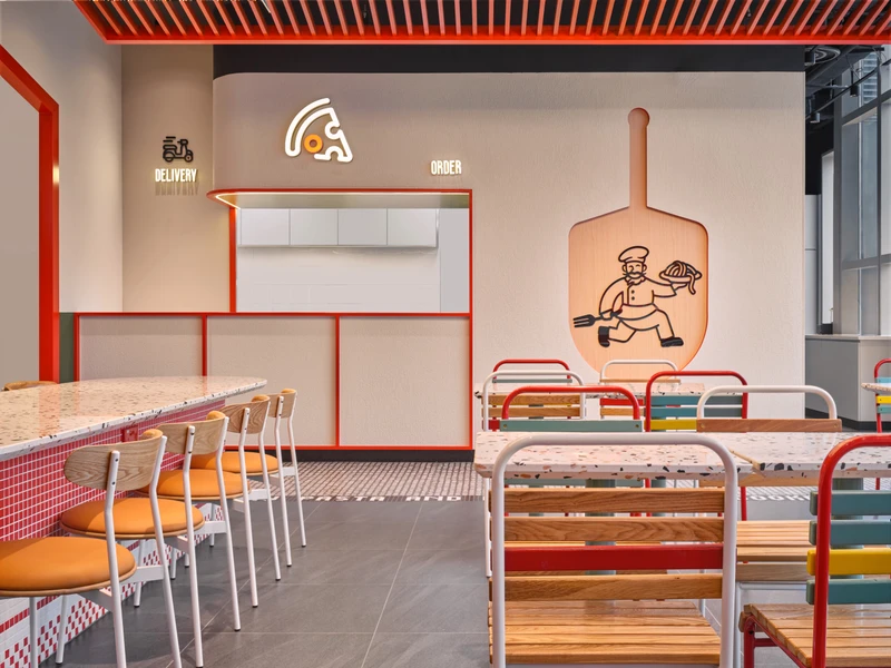Order counter with neon pizza logo, red slatted ceiling and timber shelving at PastaMania City Square Mall