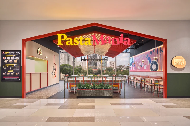 Red steel portal entrance with brand logo and communal dining beyond at PastaMania City Square Mall