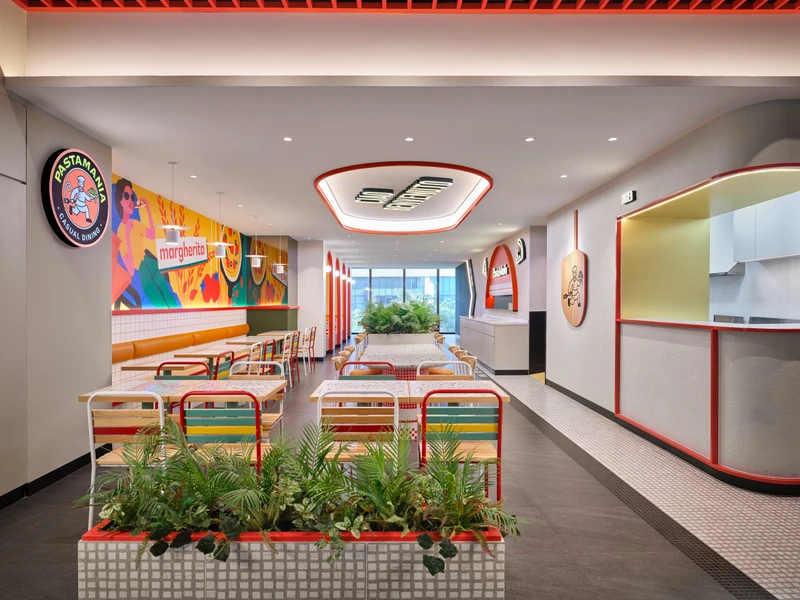 Open kitchen with red-tiled arch, porthole windows and pizza peel mascot at PastaMania Jem