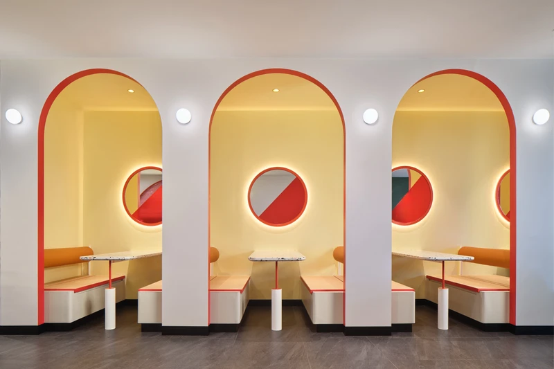 Arched booth alcoves with porthole windows and leather banquette seating at PastaMania Jem